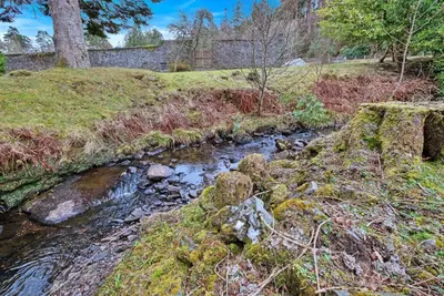 a stream in the middle of a grassy field at Turbine House in Lochgilphead