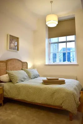 a bedroom with a bed with a window at Luxury Historic City-Centre Flat & Free Parking in Glasgow
