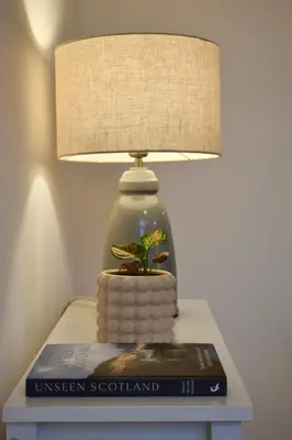 a lamp sitting on top of a table with a book at Luxury Historic City-Centre Flat & Free Parking in Glasgow