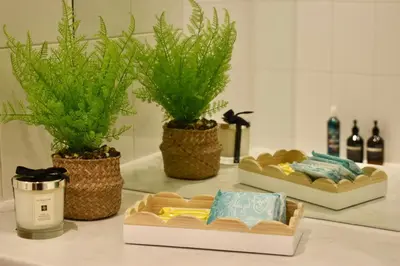 a bathroom counter with three baskets of towels and plants at Luxury Historic City-Centre Flat & Free Parking in Glasgow