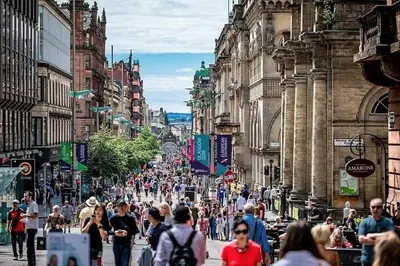 a crowd of people walking down a busy city street at Luxury Historic City-Centre Flat & Free Parking in Glasgow