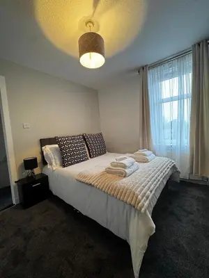 a bedroom with a large bed with a large window at Anchor stays - your steady base away from home in Cambusnethan