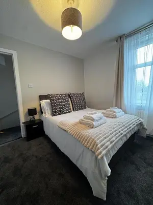 a bedroom with a bed with towels on it at Anchor stays - your steady base away from home in Cambusnethan