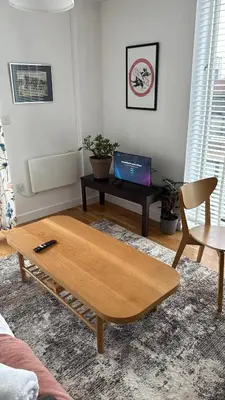 a living room with a coffee table and a laptop at Stylish Clyde Riverfront Flat with Balcony Views in Glasgow