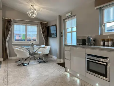 a kitchen with a table and chairs in a kitchen at Conemara - Uk51249 in Glasgow