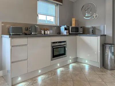 a kitchen with white cabinets and a counter top at Conemara - Uk51249 in Glasgow