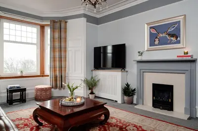 a living room with a fireplace and a table at Fir Tree Lodge - Seasgair Lodges in Crieff