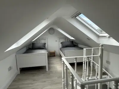 a attic room with two beds and a skylight at Mid- Village Croft in Cairndow