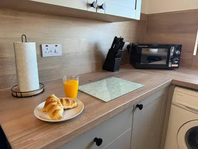 a table with a plate of croissants and a glass of orange juice at Central 1BR Apt with Parking in Auchterarder