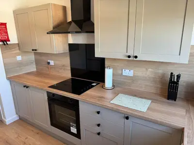 a kitchen with white cabinets and a counter with a candle at Central 1BR Apt with Parking in Auchterarder