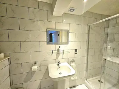 a white bathroom with a sink and a shower at Stellar Apartments - 2 & 3 Bedroom Apartments in Edinburgh