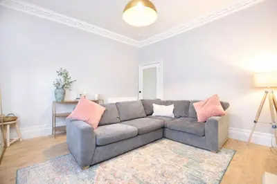 a living room with a gray couch and a rug at Portside Apartment in Greenock