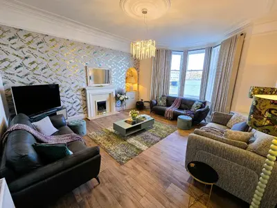 a living room with couches and a fireplace at Harbour View - Luxury Town Centre Property in Rothesay