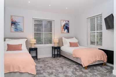 two beds in a room with two windows at Gleneagles Hideaway