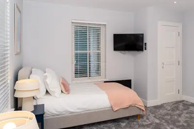 a bedroom with a bed and a tv on the wall at Gleneagles Hideaway
