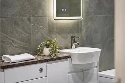 a bathroom with a sink and a mirror at Gleneagles Hideaway