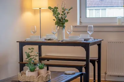 a table with wine glasses and plants on it at Raeburn House- 3 Bedrooms, 2 Bathrooms in Hamilton in High Blantyre