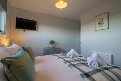a bedroom with a bed with towels on it at Raeburn House- 3 Bedrooms, 2 Bathrooms in Hamilton in High Blantyre