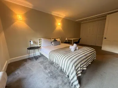 a bedroom with a bed with a teddy bear on it at Spacious Three Storey West End Home - 3 bedroom in Glasgow