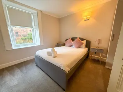 a small bedroom with a bed and a window at Spacious Three Storey West End Home - 3 bedroom in Glasgow