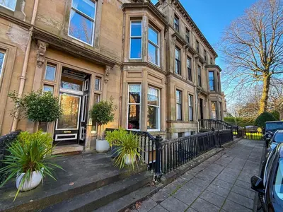 a large building with a fence in front of it at Spacious Three Storey West End Home - 3 bedroom in Glasgow