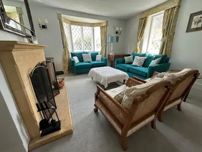 a living room with a couch and a tv at Charming Cotswold stone cottage with garden in Moffat
