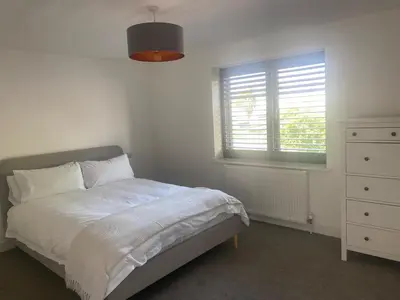 a bedroom with a bed and a dresser and a window at Tranquil Countryside Escape in Moffat
