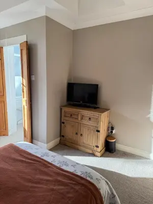 a bedroom with a television on a wooden cabinet at Auldhouse Apartment entire place 2 bedrooms in Mansewood