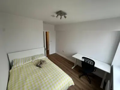 a bedroom with a bed and a desk with a pair of shoes at 3x Large Double bedroom, Central London flat in Moffat