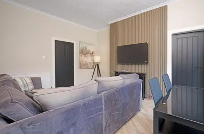 a living room with a couch and a tv at 3BR Home Sleeps 6 Near Airport with Parking