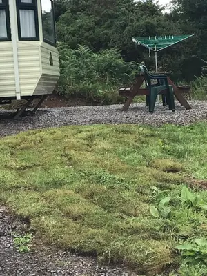 a picnic table next to a rv and a picnic table at Cruachan View Caravan Farm stay in Oban