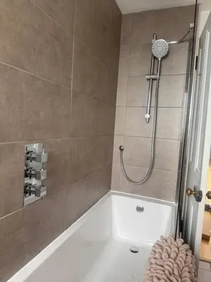 a bathroom with a shower with a white tub at Murrayfield Executive Apartment in Edinburgh