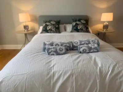 a white bed with three pillows on top of it at Murrayfield Executive Apartment in Edinburgh