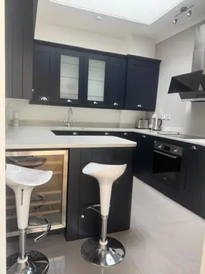 a kitchen with black cabinets and white counter tops at Murrayfield Gem in Edinburgh