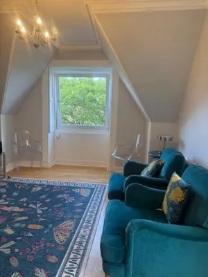 a living room with a blue couch and a window at Murrayfield Gem in Edinburgh