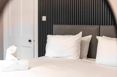 a white bed with white pillows in a bedroom at No8 Peebles Retreat - Donnini Apartments in Ayr