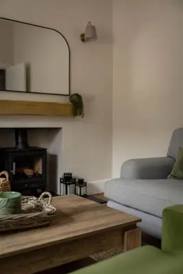 a living room with a couch and a fireplace at Cosy Callander One Bed Apartment Wood Burner and Free Parking in Callander