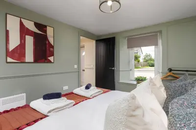 a bedroom with a white bed with towels on it at The Bruces Quarter in Stirling