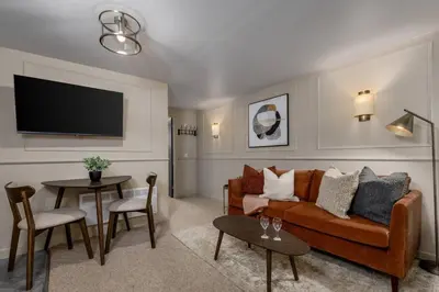 a living room with a couch and a table at Kilted Quarter by The Wallace Monument in Stirling