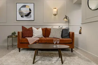 a living room with a brown couch and a table at Kilted Quarter by The Wallace Monument in Stirling