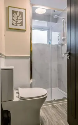 a bathroom with a toilet and a shower at Kilted Quarter by The Wallace Monument in Stirling