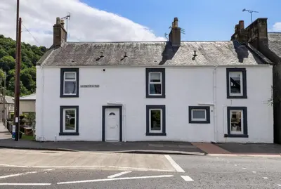 a white house with black windows on a street at Kilted Quarter by The Wallace Monument in Stirling