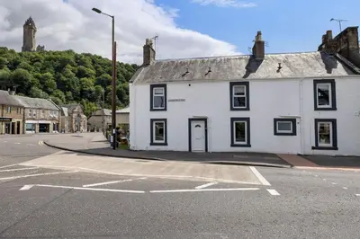 a white building on the corner of a street at Kilted Quarter by The Wallace Monument in Stirling
