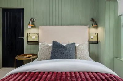 a bedroom with a large bed with two lights on it at The Braveheart Suite by The Wallace Monument in Stirling