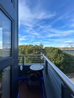 a balcony with a table and a view of the water at Duplex Penthouse with Secured Parking Finnieston in Glasgow