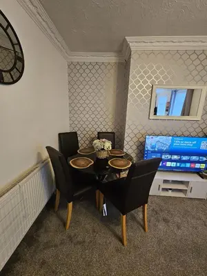 a dining room with a table and chairs and a television at Acadia House Blyth in Moffat