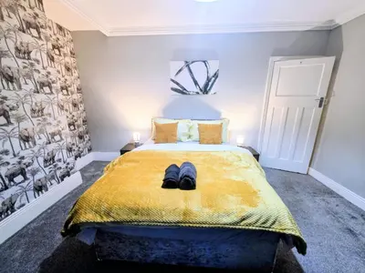 a bedroom with a bed with a pair of shoes on it at Acadia House Blyth in Moffat