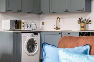 a kitchen with a washing machine and a microwave at Elegant 3 Bed Apartment in Stirling Near Free Parking and Hill Views in Stirling
