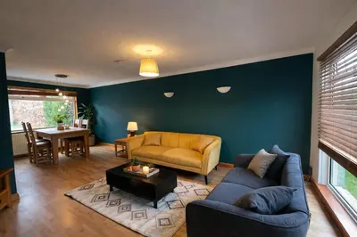 a living room with a couch and a table at Comfortable 3 Bed Home with Garden & Parking Stylish Family Contractor in Newton Mearns