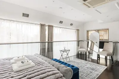 a bedroom with a large bed and two chairs at New! Modern Wapping 1BR Flat near Tower Bridge in Moffat